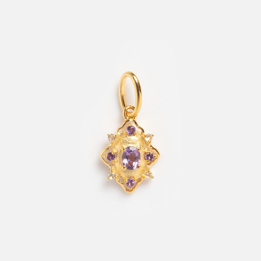The 2026 February Capsule Vintage Inspired Amethyst Charm features an ornate star-like gold pendant with a central oval amethyst, surrounded by smaller purple stones and clear accents, set against a plain white background.