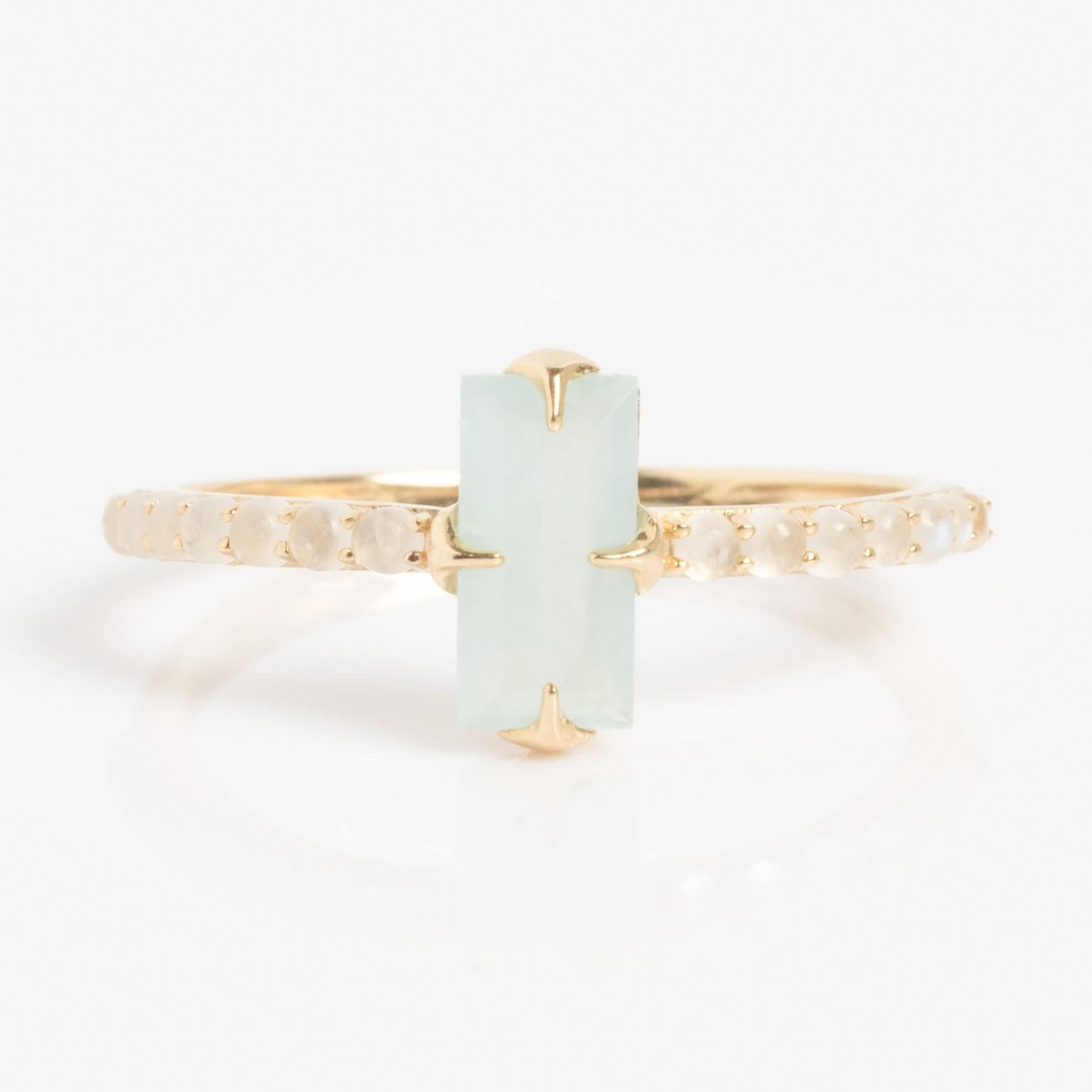 The Solid Gold 2026 March Capsule Delicate Aquamarine Solitaire Ring features a vertically set rectangular light blue-green aquamarine centerpiece, accented by small round white stones along the band.