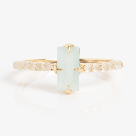 The Solid Gold 2026 March Capsule Delicate Aquamarine Solitaire Ring features a vertically set rectangular light blue-green aquamarine centerpiece, accented by small round white stones along the band.