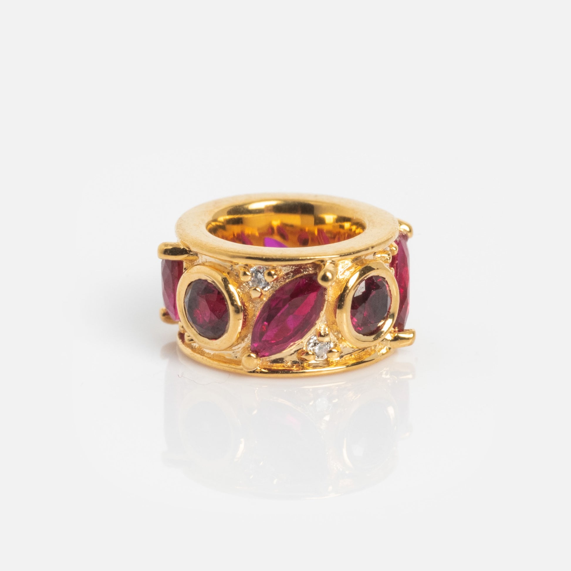 The Shades of You Birthstone Spacer Charm features large oval red gemstones and small clear stones in an ornate gold setting, displayed on a white background.