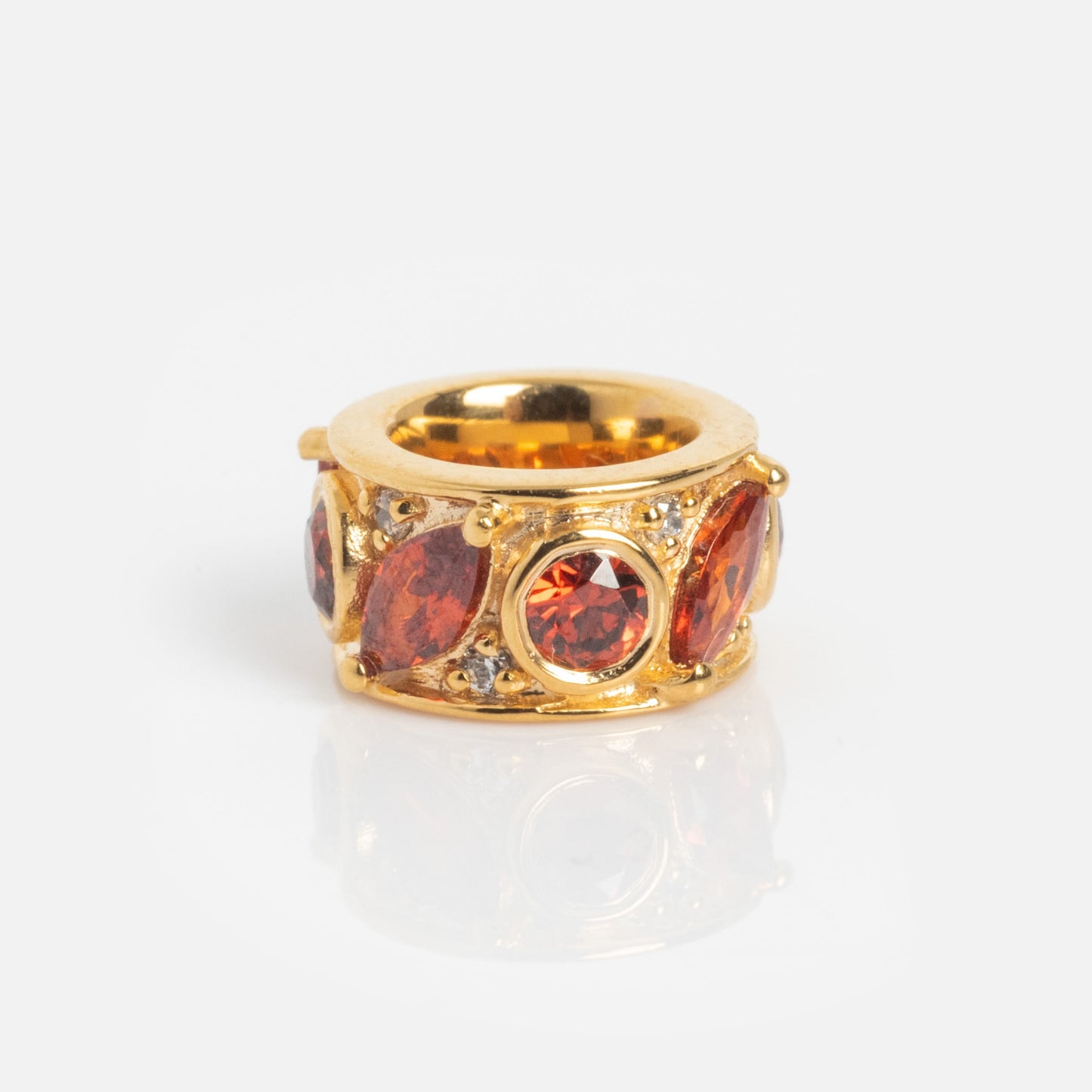 The Shades of You Birthstone Spacer Charm is a gold accessory featuring round and marquise-cut red gemstones with small clear accents, shown on a plain white background.