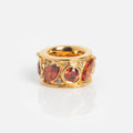 The Shades of You Birthstone Spacer Charm is a gold accessory featuring round and marquise-cut red gemstones with small clear accents, shown on a plain white background.