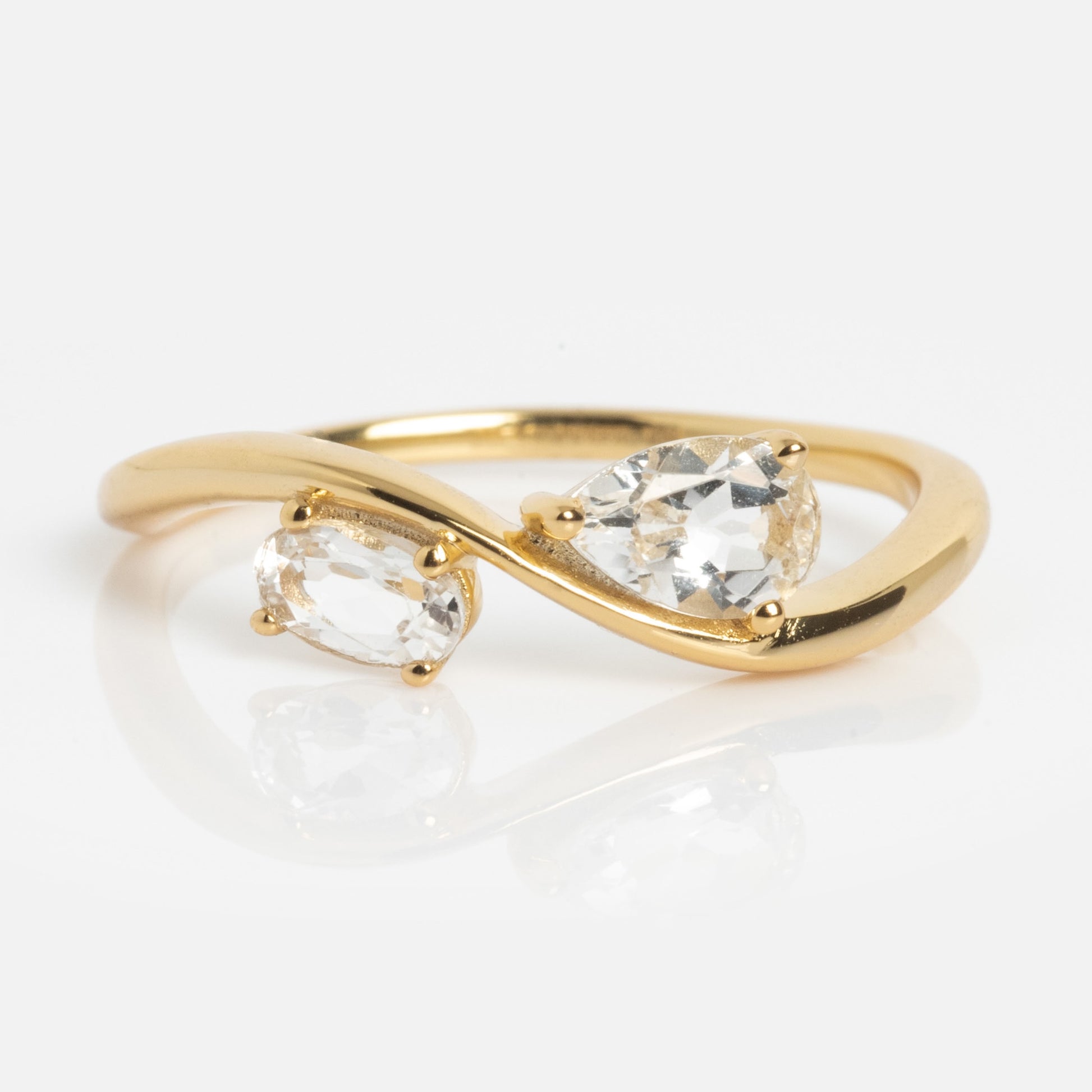 The 2026 April Capsule Floating Duo White Topaz Ring features two clear gemstones—pear and oval—in an open bypass yellow gold vermeil setting, elegantly celebrating the April birthstone.