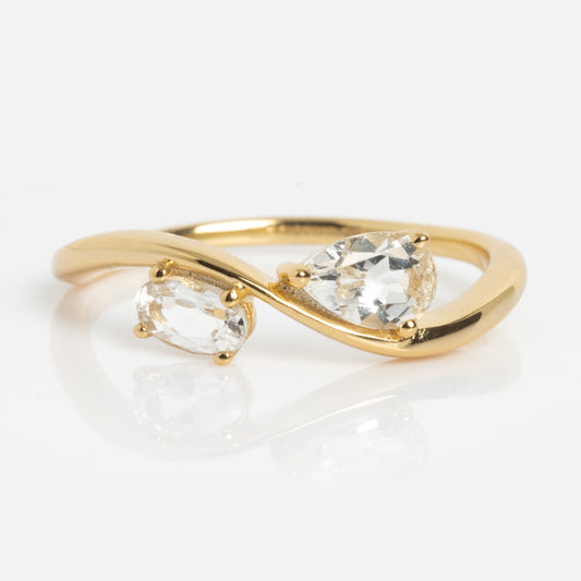 The 2026 April Capsule Floating Duo White Topaz Ring features two clear gemstones—pear and oval—in an open bypass yellow gold vermeil setting, elegantly celebrating the April birthstone.