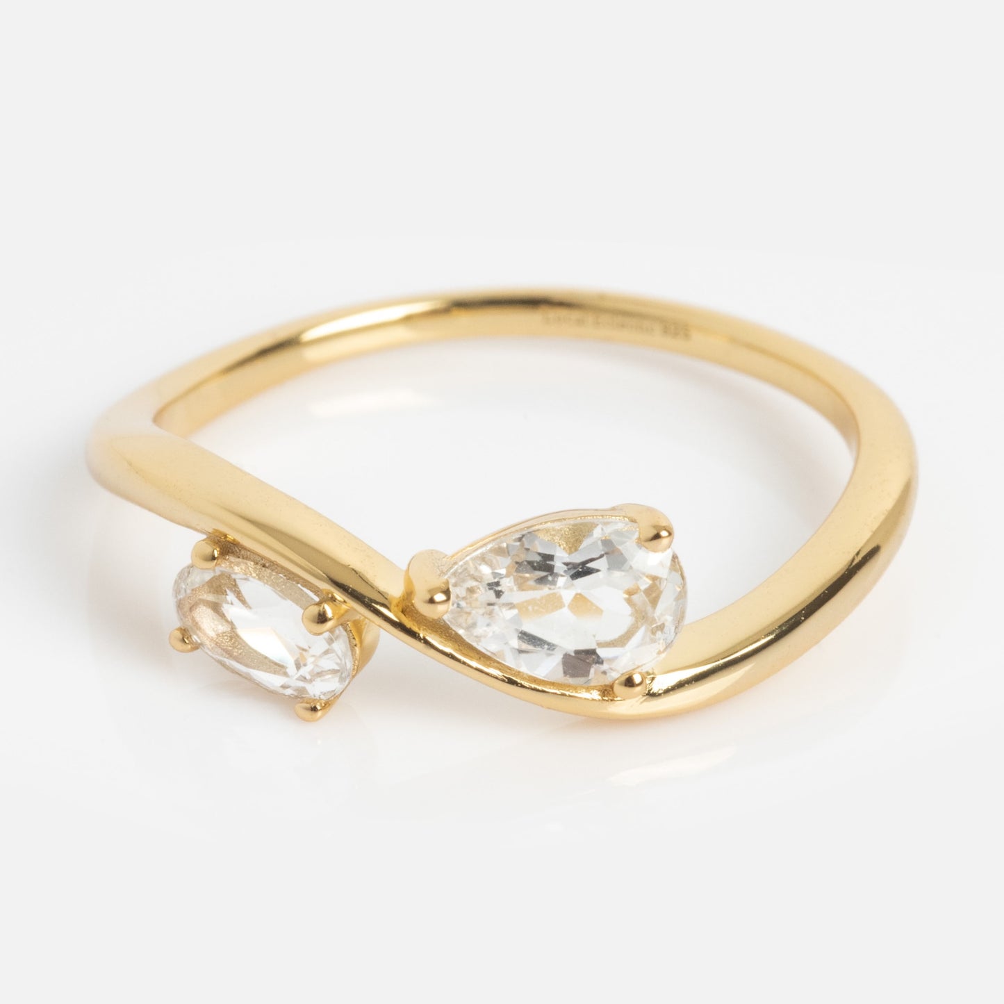 The 2026 April Capsule Floating Duo White Topaz Ring is a yellow gold vermeil ring with two pear-shaped white topaz gemstones set opposite each other in a bypass design. Ideal as an April birthstone piece or an elegant white topaz ring. Displayed on a white background.