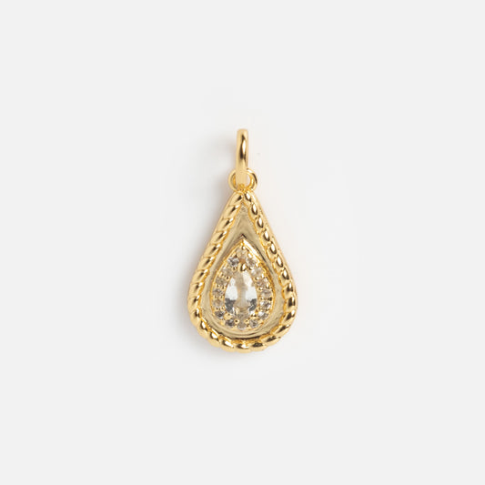 The 2026 April Capsule Tethered Teardrop White Topaz Charm features a yellow gold vermeil, teardrop-shaped pendant with a textured border and clear faceted white topaz—an elegant April birthstone charm on a plain white background.