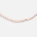 The Beaded Gemstone Necklace features small, round, translucent pale pink beads and is shown on a plain white background—ideal for lovers of natural crystal jewelry.