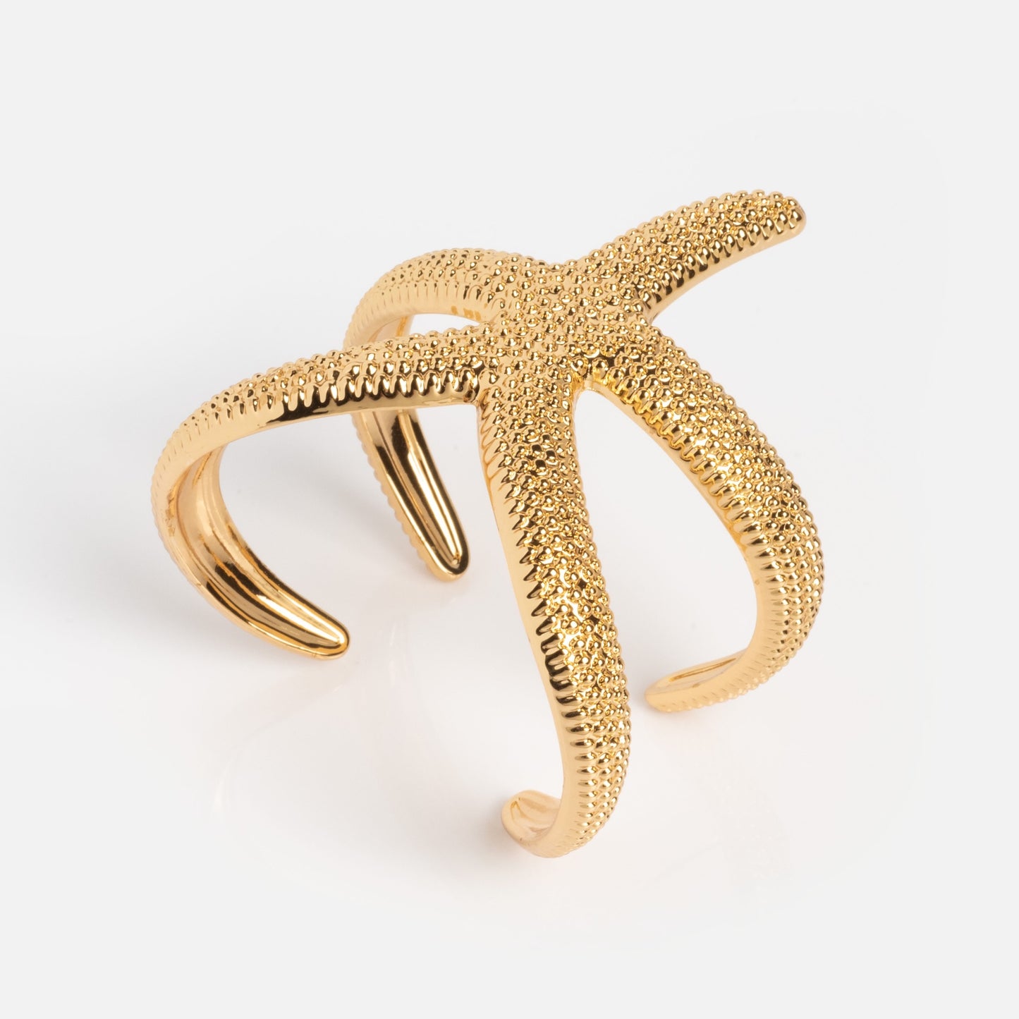 The Golden Nautilus Shell Cuff is a gold cuff bracelet featuring a textured nautilus shell design, shown on a white background.