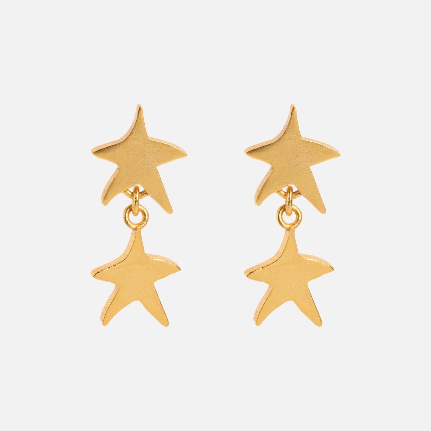 The Star Drop Earrings feature two gold star-shaped charms on each earring, with one star dangling beneath the other, shown against a plain white background.
