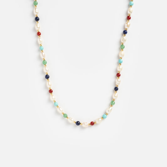 The Carrie Necklace features a repeating pattern of small white pearls and round red, blue, green, and turquoise beads on a white background.