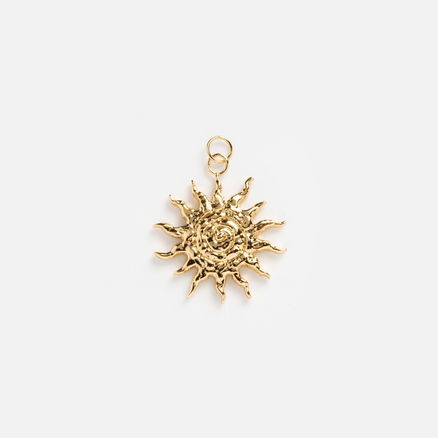The Charms by Mod + Jo gold sun-shaped pendant features wavy rays and a textured center, shining as a good luck charm against a plain white background.