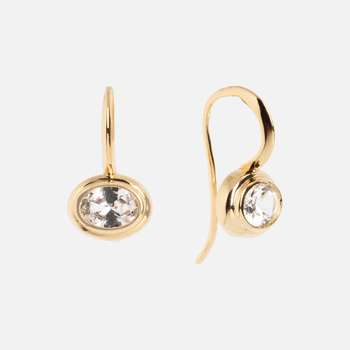 The Lucia Oval French Hook Earrings feature a single round, clear gemstone in a bezel setting on each gold drop earring, displayed on a plain white background.