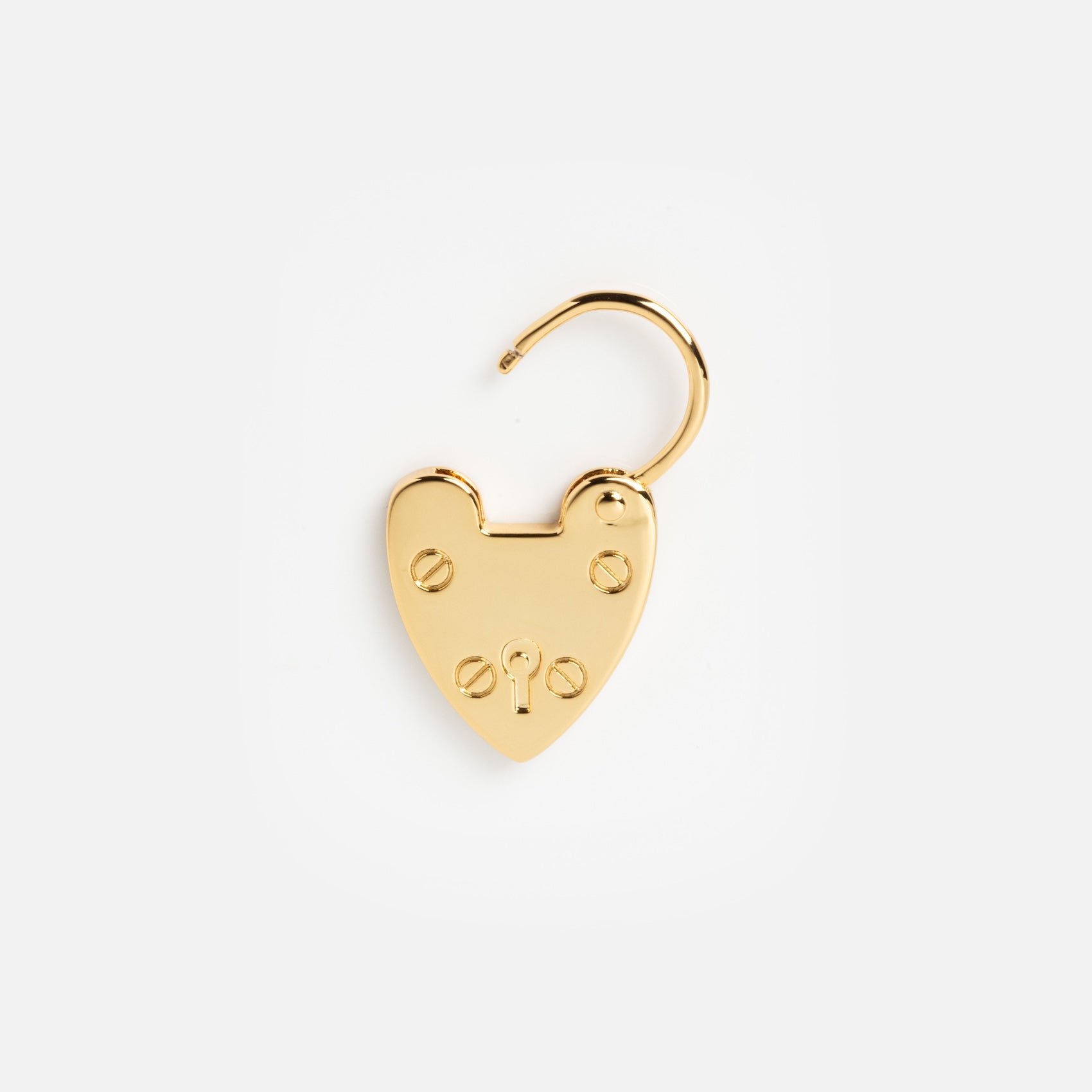 A shiny gold heart-shaped padlock charm with an open shackle, keyhole, and four screw details is photographed on a white background—a chic accessory from Charms by Mod + Jo for stylish good luck.