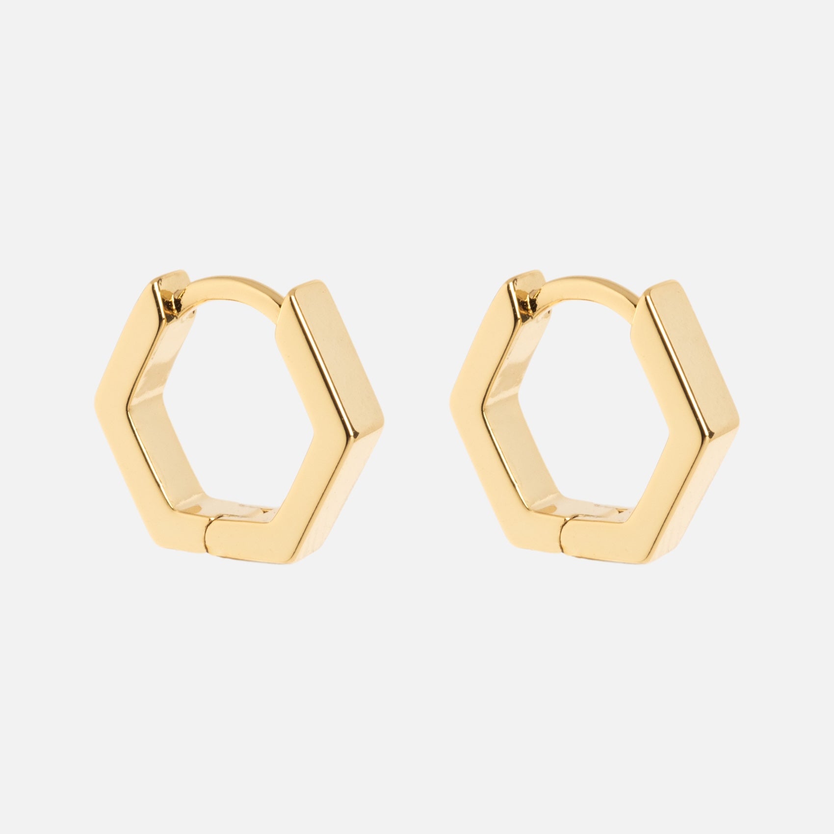 Ari Hoops: gold hexagonal hoop earrings showcased on a plain white background.