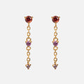 The Celebration Ombre Birthstone Drop Studs feature 14k gold plating, with red and purple gemstones linked by delicate chains—perfect personalized jewelry.