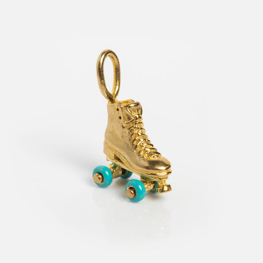 The Charms by Satomi Studio gold roller skate charm features turquoise enamel wheels and a top loop for attaching to necklaces or bracelets, shown on a plain white background.