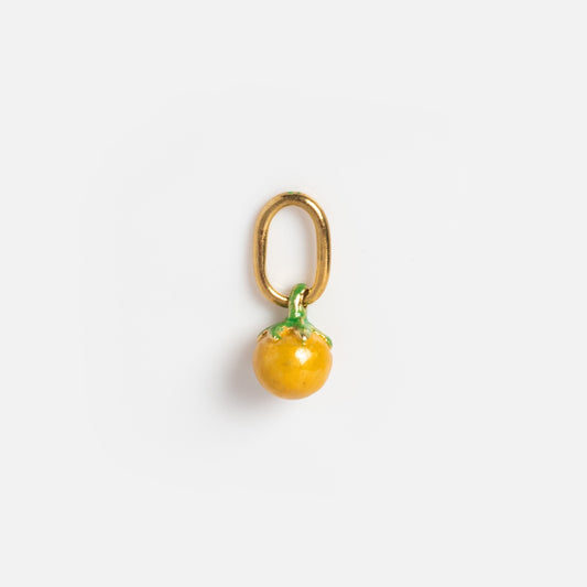 Charms by Satomi Studio: A small gold keychain or pendant with a glossy yellow enamel fruit charm and green top, resembling a tomato or orange, displayed on a plain white background.