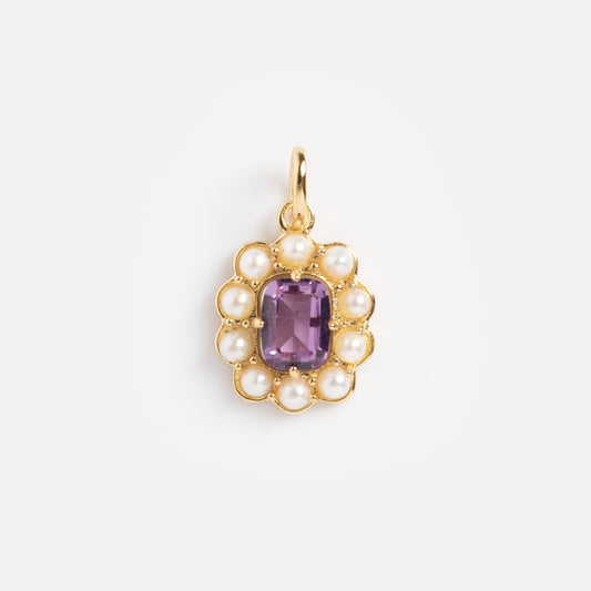 The 2026 June Capsule Vintage Inspired Alexandrite and Pearl Charm is a gold pendant with a rectangular purple alexandrite center, framed by a scalloped border of small pearls, shown against a plain white background.