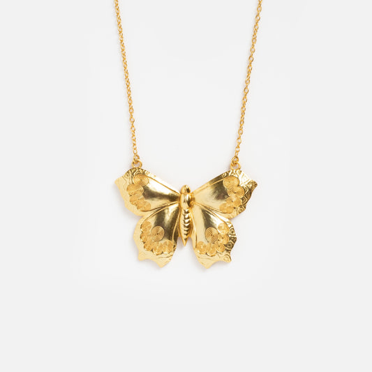 The Butterfly Necklace features a gold pendant shaped like a butterfly with intricately engraved wings, showcased on a plain white background.