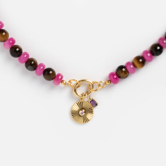 Close-up of the Beaded Gemstone Charm Holder Necklace with alternating pink and brown beads, a gold clasp, and two gold pendants—a round one with a small stone and a rectangular purple charm—ideal for gemstone necklace lovers.