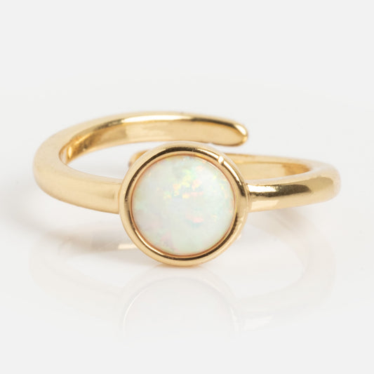 The Ease Toe Ring features a gold-plated open band with a round, iridescent simulated opal stone at the center, shown on a white background.