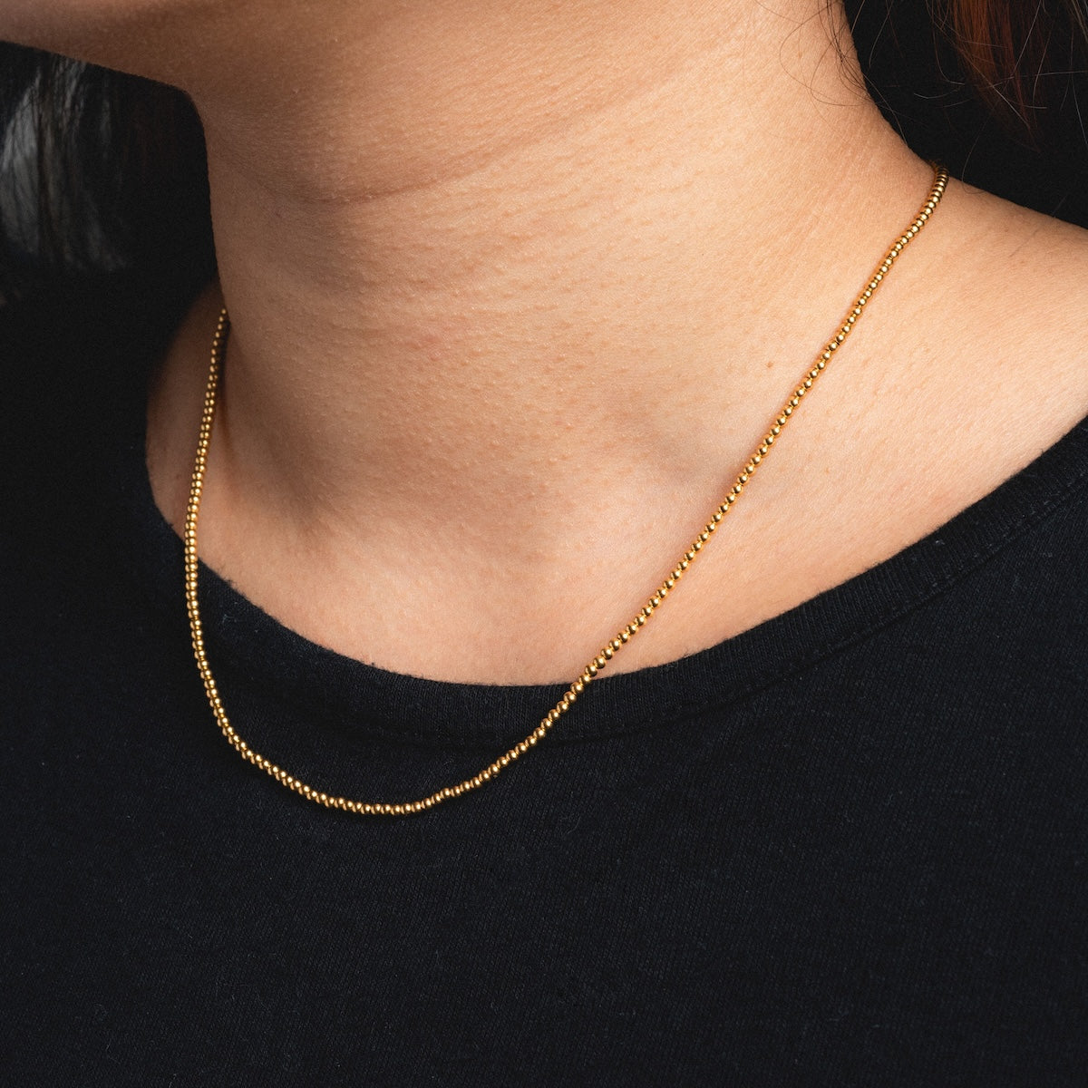 Close up of vermeil beaded chain being worn