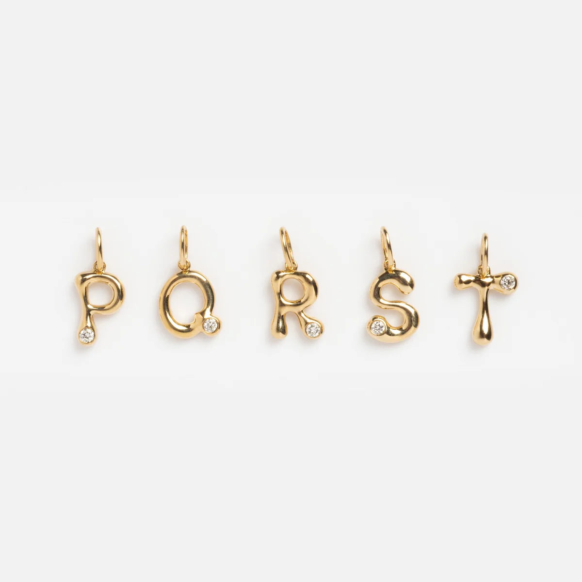 Five Solid Gold Diamond Initial Charm Samples—P, Q, R, S, and T—each crafted in 9k yellow gold with a 2 mm lab-created diamond accent—are shown in a row on a white background.