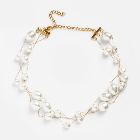 The Selah Necklace is a gold-plated, layered piece with an adjustable clasp, featuring multiple strands adorned with white pearls of varying sizes and irregular shapes.