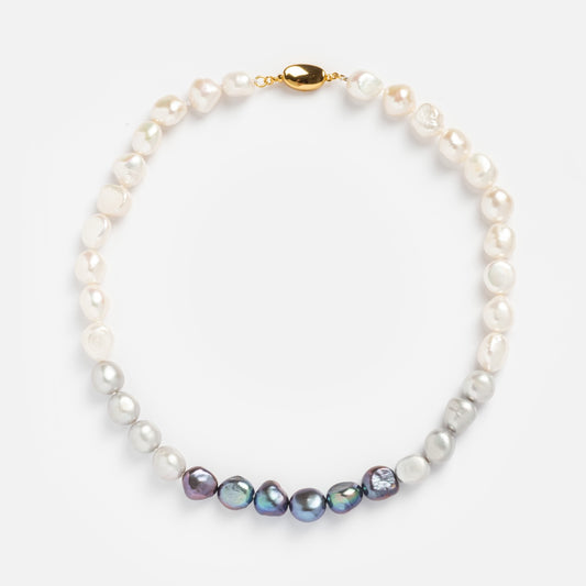 The La Fumee Necklace features baroque pearls in white, silver, and dark iridescent tones with a small gold clasp, shown on a plain white background.