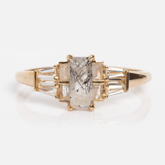 The 14k Labradorite Ring Sample Size 7 features a rectangular, translucent labradorite with dark inclusions, accented by tapered baguette-cut white topaz stones on each side, shown against a white background.
