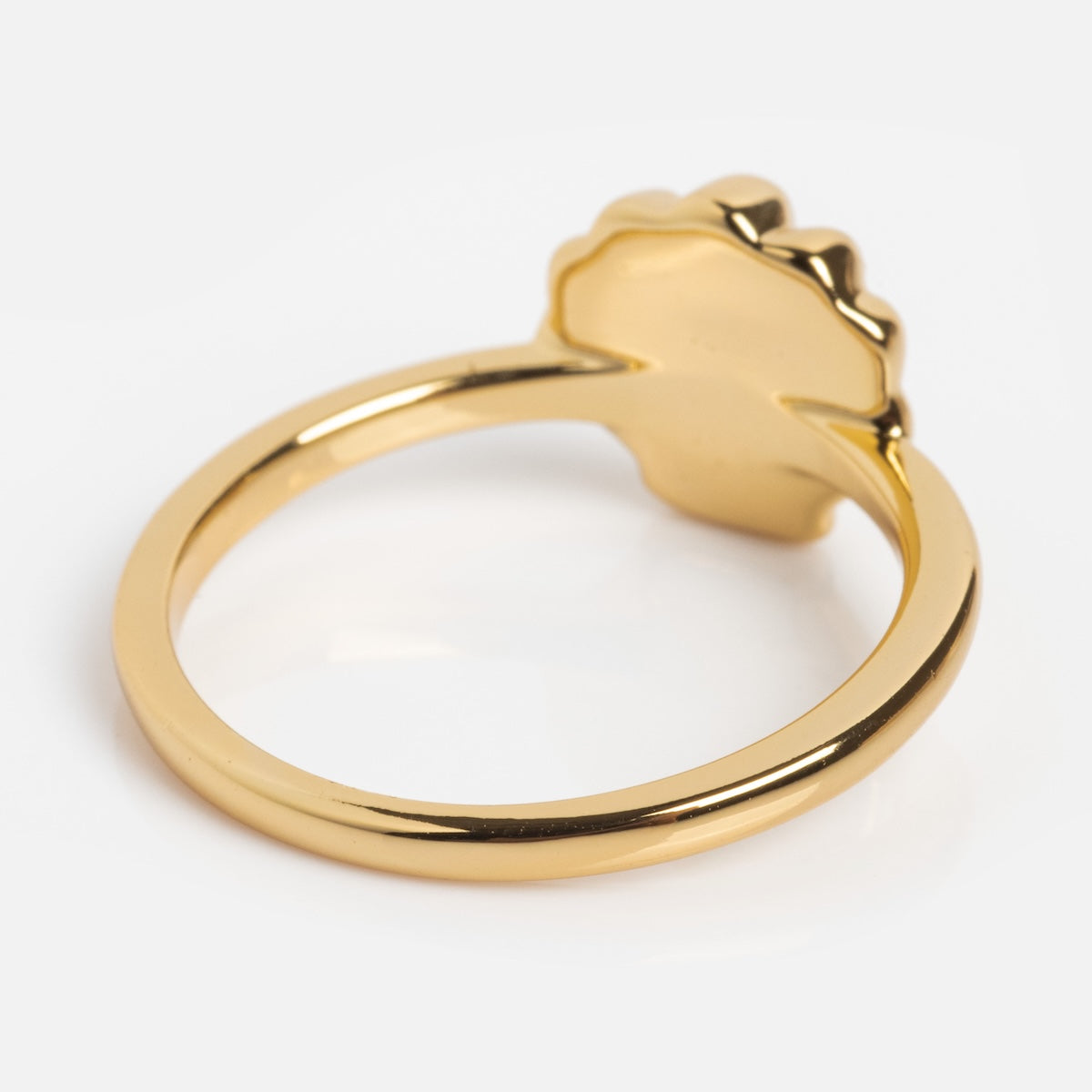 Gold ring with a heart-shaped design on a white background