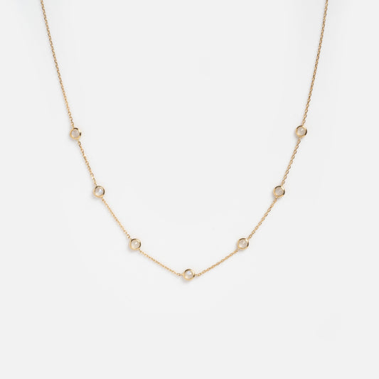 Showcased on a plain white background, the Solid Gold Birthstone Station Necklace Sample features a delicate 9k yellow gold chain with evenly spaced small circular links.