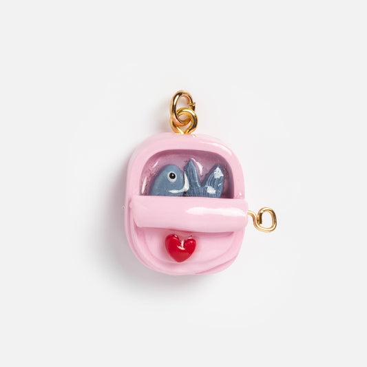 Charms by Warm Clay Co: A small pink gold-plated clay backpack charm with a gold loop, decorated with two blue fish and a red heart—an ideal unique accessory for necklace lovers.