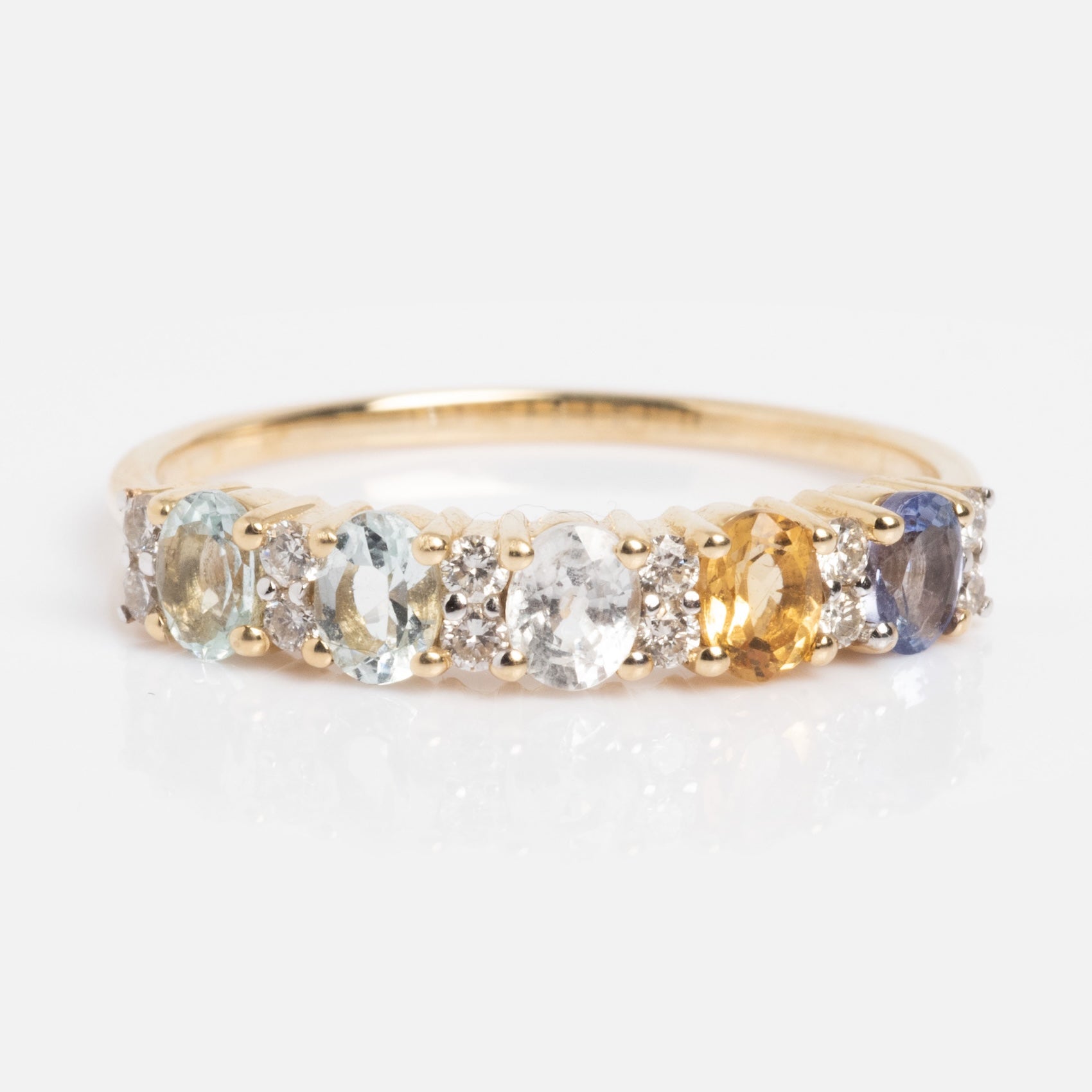 The Customizable Acrostic Oval Gemstone Ring features aquamarine, white sapphire, citrine, and tanzanite gemstones set in gold with white accent stones, shown here in size 9 against a white background.