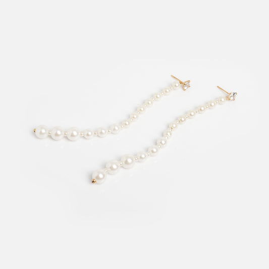 The Miami Vice Earrings Sample features long 14k gold vermeil studs with graduated white pearls in a linear design, shown on a plain white background.