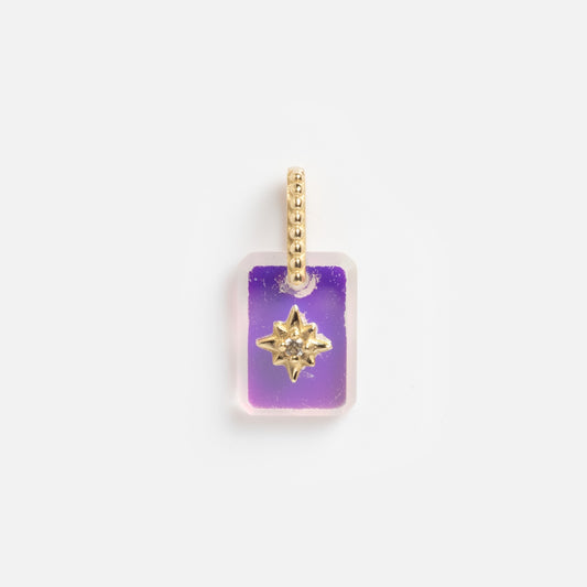 The 9k Crystal Amulet Charm for Manifestation features a rectangular purple Angel Aura Quartz pendant with a clear border, gold starburst center, and a gold beaded loop for easy chain attachment.