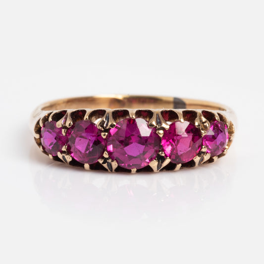 The Vintage 14k Graduated Ruby Ring Size 6 Sample showcases five round pink rubies in prong settings, arranged in a row on a gold band and displayed against a plain white background.