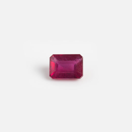 A 2.7 carat loose ruby sample, rectangular and faceted with beveled edges, is displayed against a plain white background.