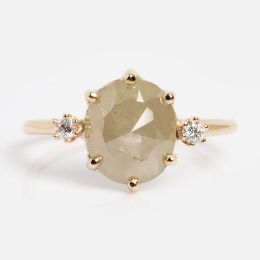The Clair de Lune Grey Diamond Ring Size 7 Sample features a central oval grey diamond flanked by two small round diamonds, all set in gold against a plain white background.