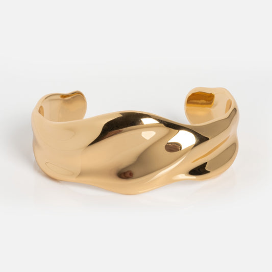 The Wavy Days Cuff is a gold cuff bracelet with a wavy design and smooth, reflective surface, showcased against a plain white background.