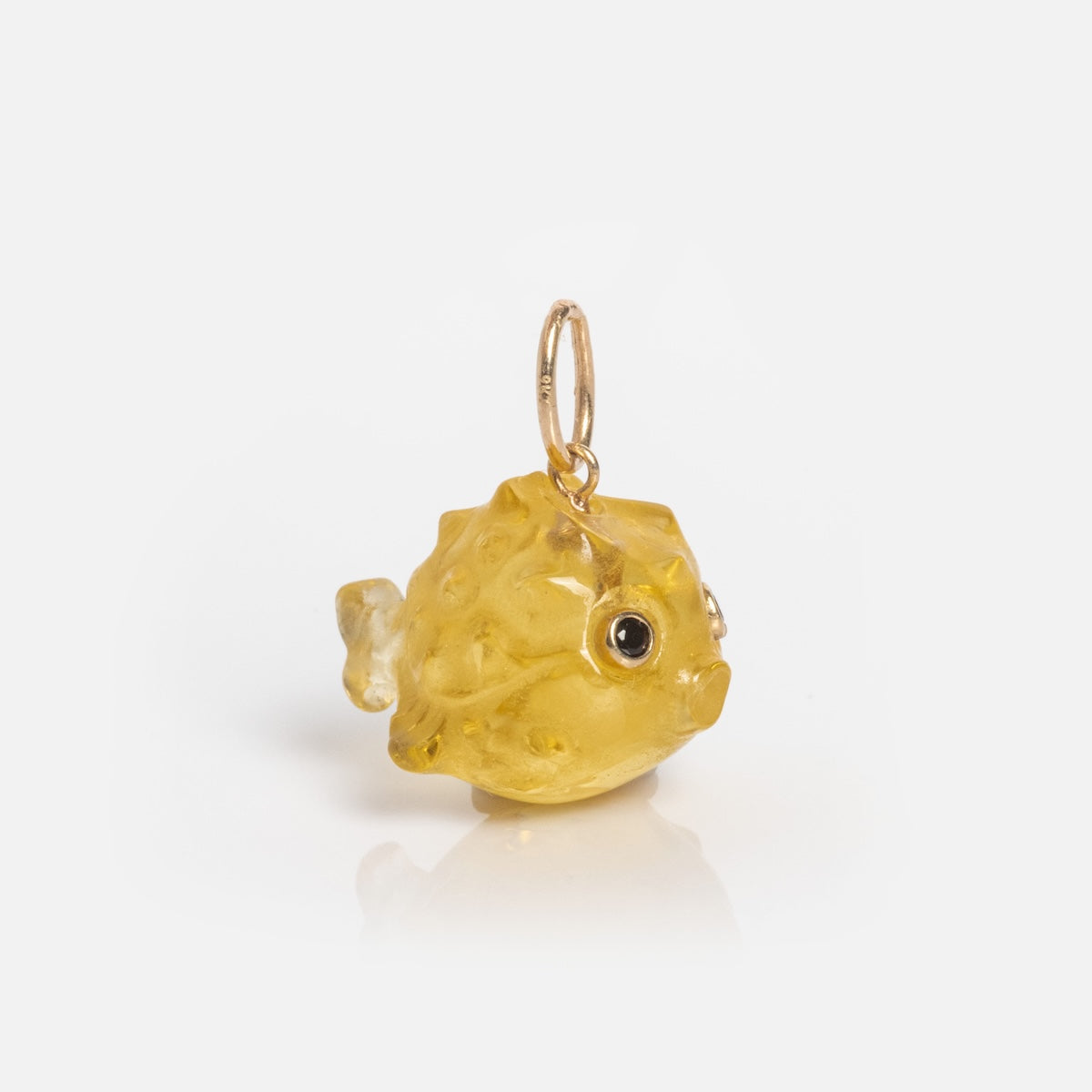 The Solid Gold Under The Sea Charm is a small, yellow, glass fish with textured details and a gold attachment loop, shown on a white background.
