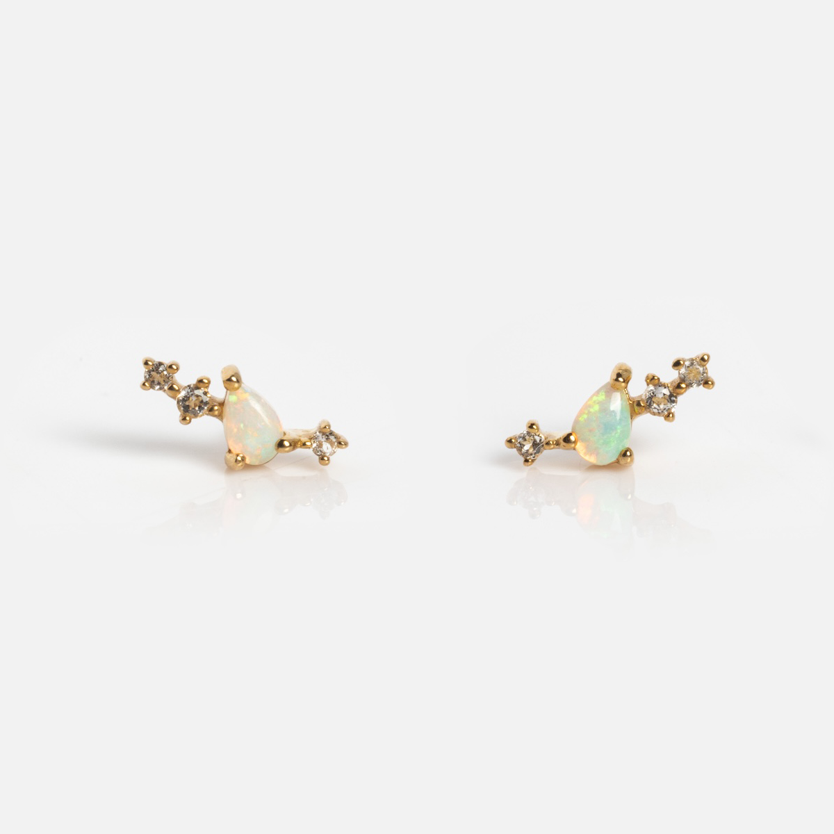 The Solid Gold Opal Constellation Flat Back Studs feature teardrop-shaped opals and star-like clusters of clear gemstones, all set against a white background.