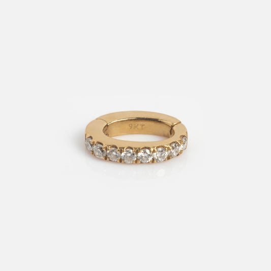The Solid Gold Ring Clip is a small gold hoop encrusted with clear round gemstones on the front, marked 9KT inside, ideal for customizing your ring stack and shown on a plain white background.