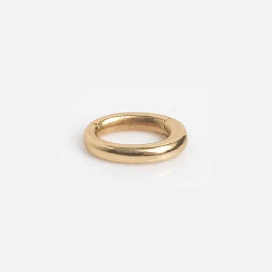 The Solid Gold Ring Clip, featuring a simple, thick design and smooth, rounded surface, is displayed on a white background—ideal for enhancing your customizable ring stack.