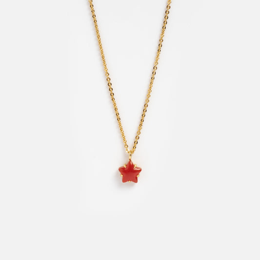 The Star Bright Necklace is a gold chain with a small, star-shaped red chalcedony pendant, shown on a plain white background.