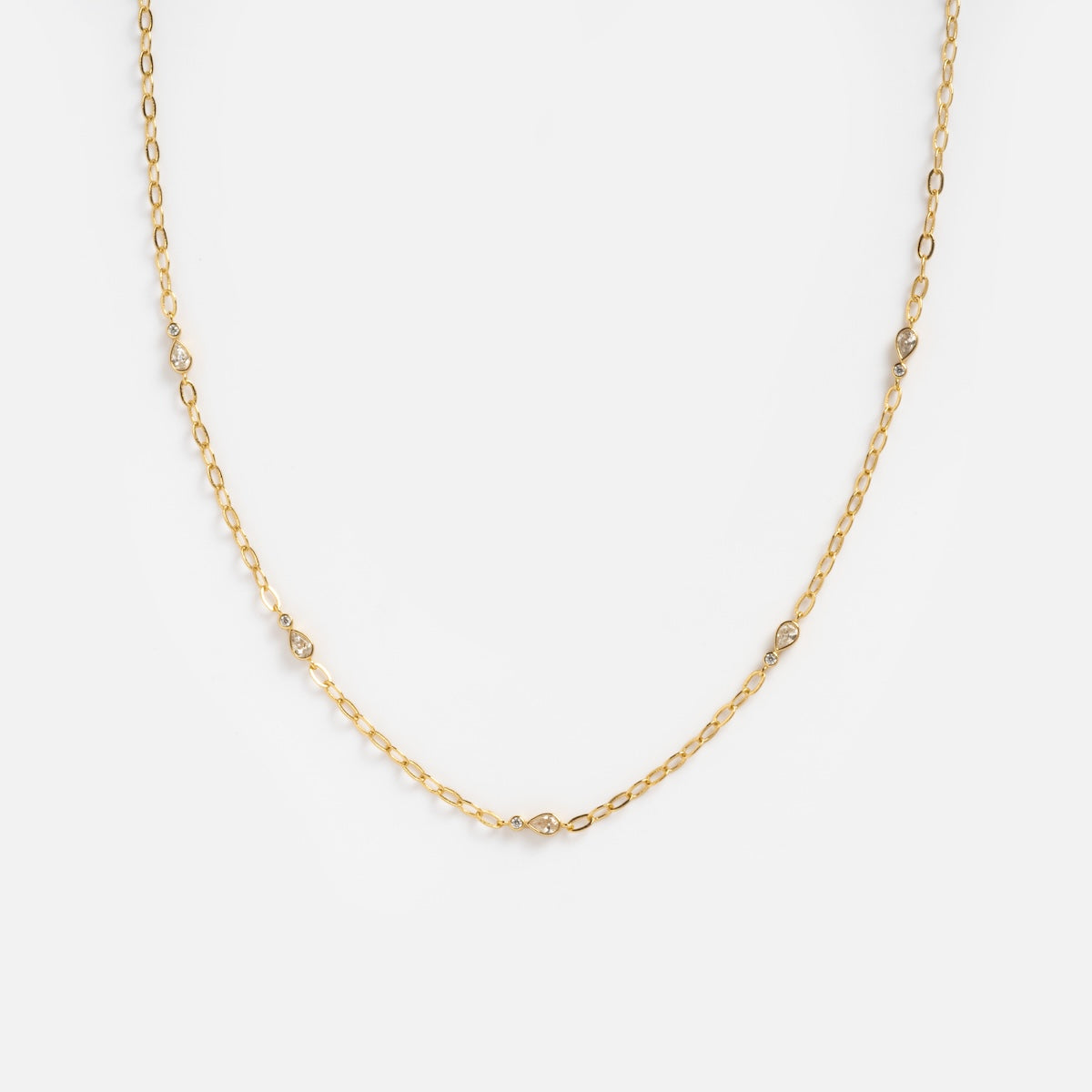 The Perfect Paperclip Layering Necklace Sample is a yellow gold plated necklace with a fine chain and small round diamond accents, beautifully displayed on a plain white background.