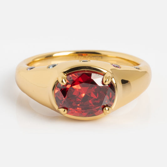 Gold ring with a red gemstone on a white background