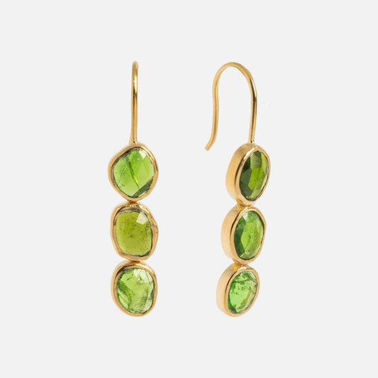 Amber Earrings: Gold-plated drop earrings with three vertically aligned green tourmaline gemstones in bezel settings, shown on a plain white background.