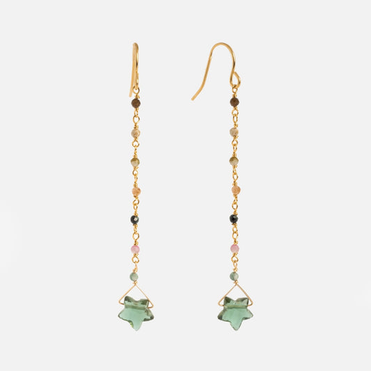The Bangalore Earrings are long, yellow gold plated, with small multicolored beads along the chain and a green star-shaped stone pendant at the end, displayed on a white background.
