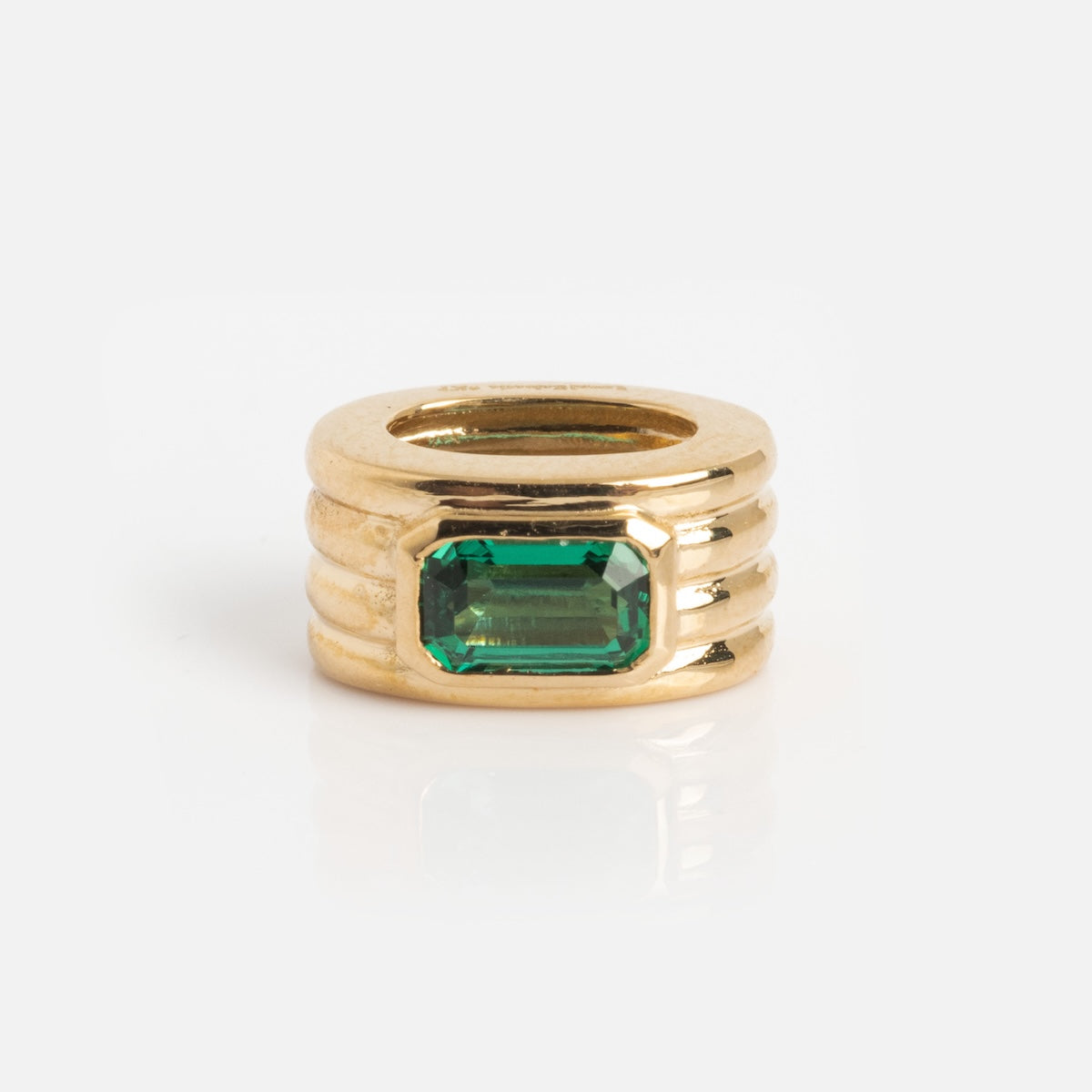 The Solid Gold Bold Birthstone Spacer Charm is a chunky gold ring featuring three horizontal ridges and a rectangular green gemstone in the center, displayed against a plain white background.